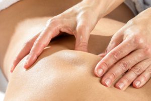 Extreme close up of hands massaging shoulder blade on female patient.
