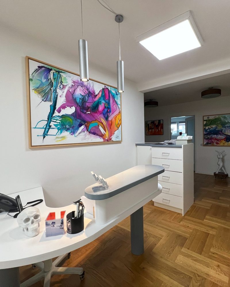 Empfangsbereich der Praxis Kukla mit Kunst an der Wand